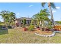 Lush landscaping surrounds this home, complete with rock borders and beautiful plants at 125 Golf Club Ln, Venice, FL 34293