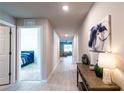 Hallway with neutral paint, hard surface flooring, accent furniture, and a glimpse into the bedroom at 13339 Flaherty Ave, Port Charlotte, FL 33981