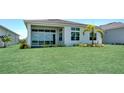 Spacious backyard featuring a large green lawn and a modern home with large windows, perfect for outdoor enjoyment at 17916 Palmiste Dr, Bradenton, FL 34202