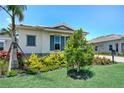 Well-maintained home featuring vibrant landscaping and blue shutters, set against a bright blue sky at 17916 Palmiste Dr, Bradenton, FL 34202