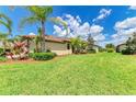 Well-maintained backyard featuring lush green grass, tropical landscaping, and a serene, inviting outdoor space at 19889 Benissimo Dr, Venice, FL 34293