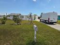 A view of the front yard, showing the lawn, bushes, and a van in the driveway of the house at 2061 Georgia Ave, Englewood, FL 34224