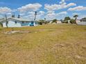 Picture of a large vacant lot with some grasses and weeds with blue skies and clouds at 2061 Georgia Ave, Englewood, FL 34224
