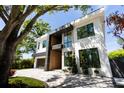 Modern home with clean lines and contrasting textures, featuring black-framed windows and meticulous landscaping at 2375 Floyd St, Sarasota, FL 34239