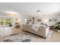 Bright, open living room with tile floors, neutral tones, and a comfortable seating area, seamlessly flowing into the kitchen at 2933 Mayflower St, Sarasota, FL 34231