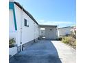 Clean mobile home exterior with an attached carport and well-manicured garden, offering privacy at 3414 Spanish Oak Ter, Sarasota, FL 34237