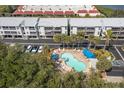 Aerial view of condo complex featuring community pool, lush landscaping, and beach access at 3601 East Bay Dr # 205, Holmes Beach, FL 34217