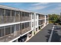 Condo building exterior with screened in porch overlooking parking and landscaping at 3601 East Bay Dr # 205, Holmes Beach, FL 34217