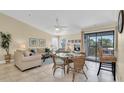 Bright living room features tile floors, dining area, comfortable furniture, and balcony access at 3601 East Bay Dr # 205, Holmes Beach, FL 34217
