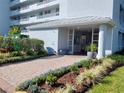A well-maintained condominium entrance with professional landscaping and a brick walkway at 3780 Pinebrook Cir # 102, Bradenton, FL 34209