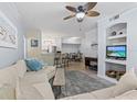 Bright open-concept living room with ceiling fan, modern furniture, and bar seating at the kitchen counter at 4178 Central Sarasota Pkwy # 325, Sarasota, FL 34238