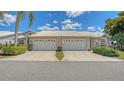 Two-car garage with a tile roof, nice landscaping, and a well maintained concrete driveway at 4181 Brittany Ln # 25, Sarasota, FL 34233