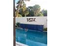 Beautiful pool area with waterfall feature, tiled wall, and tropical landscaping at 4408 Midnight Pass Rd, Sarasota, FL 34242
