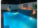 Stunning backyard pool with lit waterfall feature, elegant tiling, and lush greenery at 4408 Midnight Pass Rd, Sarasota, FL 34242