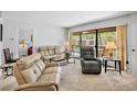 Cozy living room with access to the lanai overlooking the community pool, with comfortable seating at 4632 Ringwood Mdw # 28, Sarasota, FL 34235