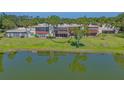 Exterior view of condo building overlooking lake and landscaped grounds with mature trees, creating a serene setting at 515 Spring Lakes Blvd # 515, Bradenton, FL 34210