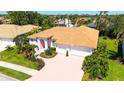Aerial view of a pink single-story home with an orange roof and a spacious three-car garage at 5270 Far Oak Cir, Sarasota, FL 34238