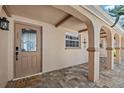 Inviting front porch featuring brick flooring, arched entryways, and a decorative front door at 5563 America Dr, Sarasota, FL 34231