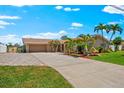 Charming single-story home with lush tropical landscaping, expansive driveway, and a welcoming two-car garage at 5563 America Dr, Sarasota, FL 34231