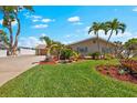 Beautiful lawn and landscaping surround this lovely home with swaying palm trees and a manicured lawn at 5563 America Dr, Sarasota, FL 34231