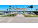 Waterfront pool with pergola, landscaping, and community area overlooking the water at 5963 Midnight Pass Rd # 355, Sarasota, FL 34242