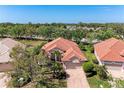 Stunning aerial view of a home with red tile roof, brick driveway, and mature landscaping at 6324 41St E Ct, Sarasota, FL 34243