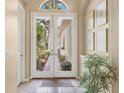 Light and bright foyer with tile floors, art, and double-door entryway at 7816 Ashley Cir, University Park, FL 34201