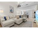 Bright open-concept living room featuring vaulted ceiling and cozy sectional sofa at 800 S Blvd Of The Presidents # 3, Sarasota, FL 34236