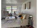 Inviting living room with neutral tones, comfortable seating, and natural light from the window at 831 Bacon Ave, Sarasota, FL 34232
