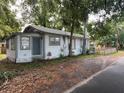 Side exterior view of the home with a blue door, white siding and a small, grassy area at 1002 E Ida St, Tampa, FL 33603