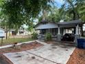 View of the front exterior of a quaint house with a covered carport and landscaped yard at 1002 E Ida St, Tampa, FL 33603