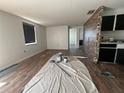 Open-concept living room featuring wood floors, and a stone-clad accent wall at 107 Grove Rd, Venice, FL 34293