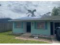 Charming single-story home featuring light turquoise siding and neat landscaping at 109 Colonia W Ln, Nokomis, FL 34275