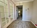 Bright entryway features wood-look tile flooring, with glass paneled french doors leading to an office at 11499 Renaissance Blvd, Venice, FL 34293