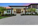 Inviting front entrance with double doors, decorative planters, and lush landscaping at 1208 Oak Hammock Rd, Sarasota, FL 34240