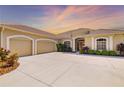 Stunning home exterior featuring a three-car garage and lush landscaping at 12810 Kite Dr, Bradenton, FL 34212