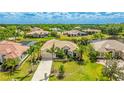 Beautifully landscaped home with a well-manicured lawn and a tile roof is surrounded by mature trees at 12822 Kite Dr, Bradenton, FL 34212