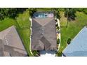 Aerial view showing the home's backyard with a screened pool, hot tub and mature trees at 12841 Balsam Ter, Bradenton, FL 34212