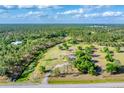 Stunning aerial view showcases the property's generous lot and surrounding lush landscape and nearby creek at 1668 Tropicaire Blvd, North Port, FL 34286