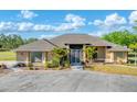 Spacious ranch home boasts tropical landscaping, a circular drive, and gated entry for enhanced privacy at 1668 Tropicaire Blvd, North Port, FL 34286