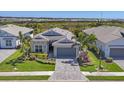 Beautiful single-story home featuring a well-manicured lawn and a paved driveway leading to a two-car garage at 17675 Azul Dr, Lakewood Ranch, FL 34202