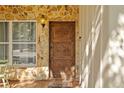 Close-up featuring the detailed, carved wood of the front door entrance with stone and tiled flooring at 2110 Euclid Ter, Sarasota, FL 34239
