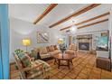 Inviting living room featuring exposed beams, a stone fireplace, and stylish, colorful furnishings at 2110 Euclid Ter, Sarasota, FL 34239