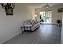 Bright living room features sliding glass doors to a screened patio overlooking tropical trees and new vinyl flooring at 2340 Canal Dr # G-35, Bradenton, FL 34207