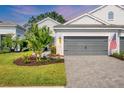 Beautiful home with an attached two-car garage, paver driveway, and an American flag at 2628 Sapphire Blue Ln, Bradenton, FL 34211