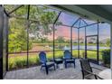 Relaxing screened patio with comfortable seating overlooking a serene lake view at 2628 Sapphire Blue Ln, Bradenton, FL 34211