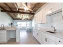 Bright, remodeled kitchen with white cabinets, marble countertops, and exposed wood beam ceilings at 2703 Avenue B, Holmes Beach, FL 34217
