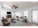 Bright living room with fireplace, ceiling fan, and white sofa near the door and large windows at 2703 Avenue B, Holmes Beach, FL 34217