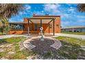 Property featuring a cozy covered patio, a manicured lawn, and an ornate statue at 280 W Cowles St, Englewood, FL 34223