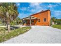 The charming exterior presents a covered patio, verdant lawns, and a lengthy driveway at 280 W Cowles St, Englewood, FL 34223